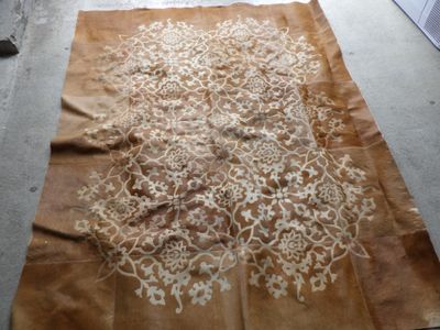 a brown rug with a white design on it
