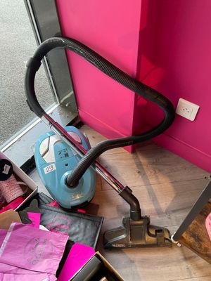 a vacuum that is sitting on the floor next to a pink wall