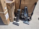 a pile of boxes and a vacuum on the floor