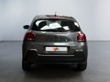 the back of a silver car in a white room with a black floor