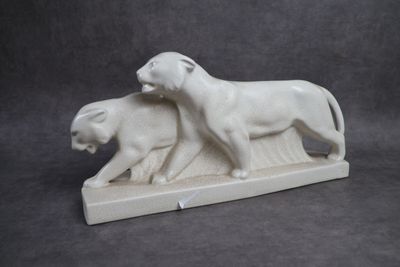 statue représentant un lion et une lionne sur un socle en pierre