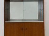 un meuble en bois avec une porte en verre dans une pièce