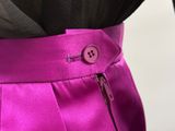 a close up of a woman ' s pink skirt with a button on it