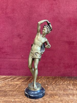 a bronze statue of a man with a hat on his head