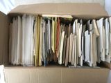 une boîte en carton remplie de dossiers et de papiers posée sur un lit