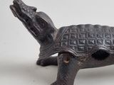 a small metal turtle that is sitting on a table
