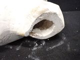 a white object with a hole in it on a black surface