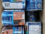 several cans of paint are in a cardboard box on a table