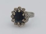 a close up of a ring with a blue stone surrounded by white diamonds