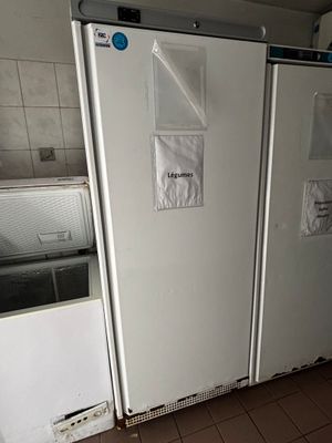 deux réfrigérateurs qui se trouvent dans une cuisine au sol carrelé