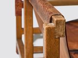 a close up of a chair with a wooden seat