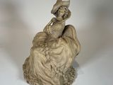 une statue représentant une femme assise sur un rocher