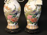 pair of chinese vases with peacocks and flowers on black background