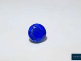 gros plan d'une pierre bleue sur une surface blanche