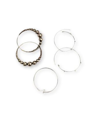 trois bagues et un bracelet en perles sont posés sur une surface blanche
