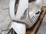 un scooter blanc exposé dans un garage