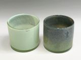 two cups sitting next to each other on a white surface