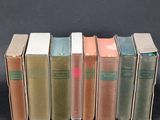 several old books are lined up on a black surface