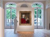 a painting of a man in a red coat in a large room