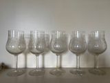 five wine glasses lined up on a table