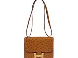 a brown ostrich bag with a gold h on the front