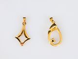 two gold pendants of different shapes and sizes on a white surface