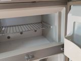 an open refrigerator with a microwave on top of it