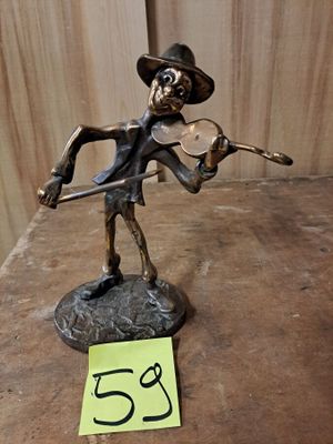 une statue représentant un homme jouant du violon sur une table