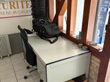 a white desk with a black chair and a black bag on it