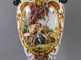 un grand vase avec un tableau posé sur une table