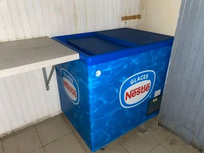 un réfrigérateur bleu posé dans un coin de la pièce
