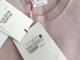 pink sweater with a tag on the back of it and a tag attached to the back of the sweater
