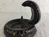 a black snake that is sitting on top of a bowl
