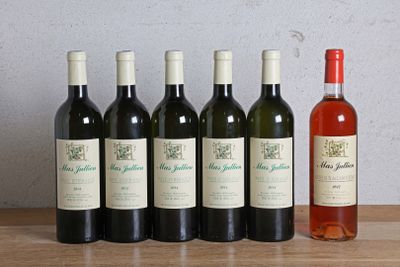 six bottles of wine sitting on a table next to a bottle of wine