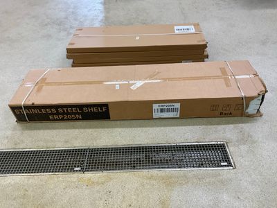 deux caisses de grilles métalliques posées par terre à côté d'une grille métallique