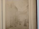 an old photo of a woman walking down a street
