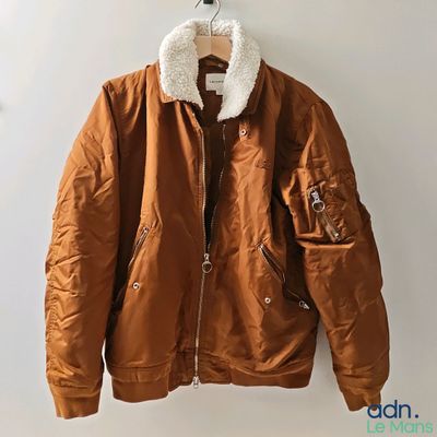 an image of a brown jacket hanging on a white wall