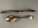 two spoons and a knife sitting on top of a table