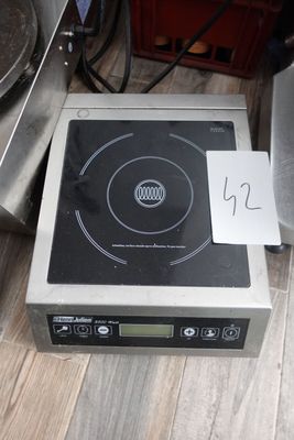 une plaque de cuisson noire et argentée sur laquelle est posée une pancarte
