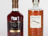 deux bouteilles de rhum et une bouteille de rhum vide posées sur une surface blanche
