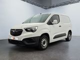 La camionnette blanche est garée dans une grande pièce.