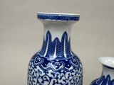 two blue and white vases sitting next to each other
