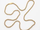 un collier en or représentant une corde torsadée sur fond blanc