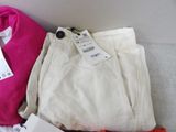 two pairs of white pants and a pink sweater