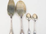 three silver spoons and two silver spoons on a white surface