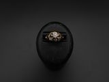 a gold ring sitting on top of a black stone