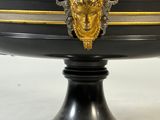 a black and gold bowl with a face on it