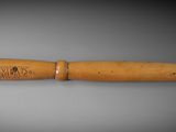 an old wooden pen with a wooden handle on a gray surface