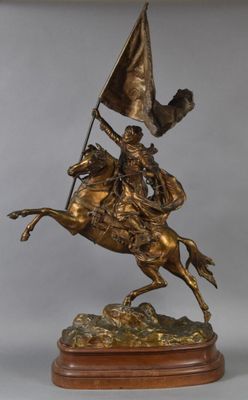 statue représentant un homme à cheval tenant un drapeau, posée sur un socle en bois