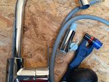 a faucet with a hose and a bag on the floor